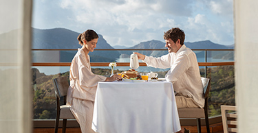 A couple enjoy an al fresco breakfast on the balcony of their room at the D Maris Bay resort.